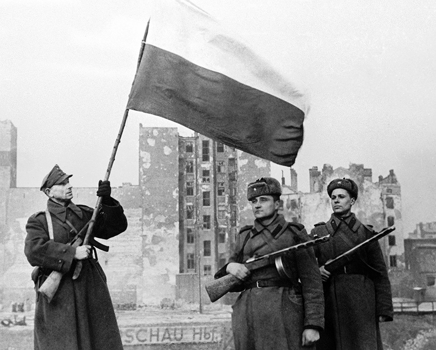 Soldat de l’Armée populaire polonaise (à gauche) et soldats soviétiques (à droite), dressant un drapeau à Varsovie, venant d’être libérée. 17 janvier 1945.