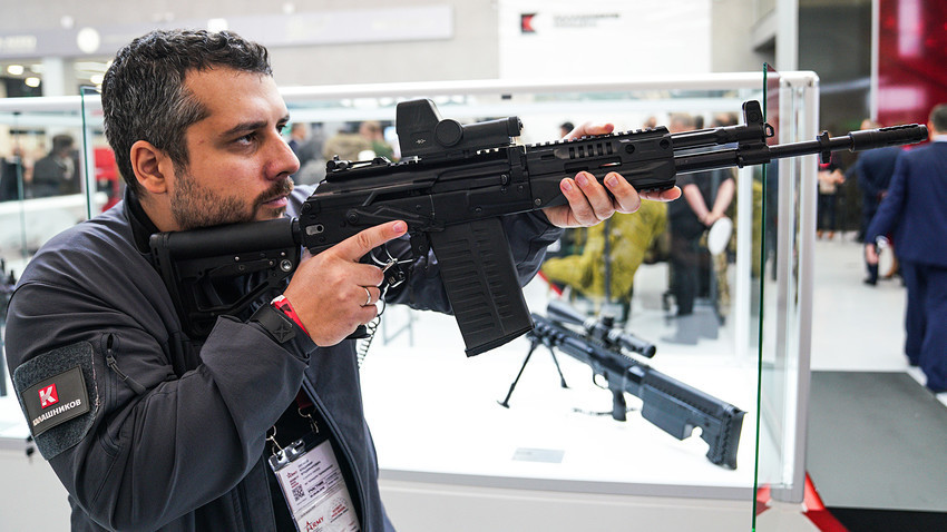 Seorang pengunjung dengan senapan serbu Kalashnikov AK-308 pada pameran Army-2018.