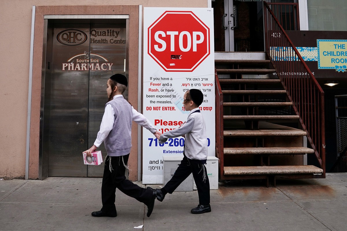 25 април 2019, Њујорк, САД. Деца покрај знак за предупредување за масовна појава на мали сипаници во Бруклин.