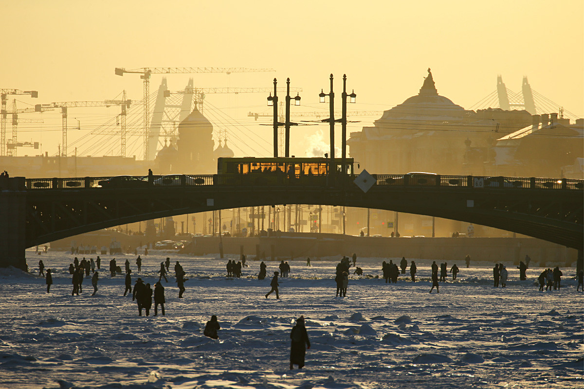 Ljudi se šeću zamrznutom Nevom u centru Sankt-Peterburga početkom ožujka. Sankt-Peterburg, Rusija, 4. ožujka 2018.