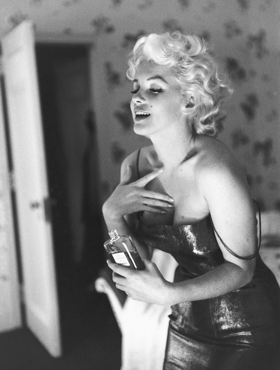 Marilyn Monroe posiert mit einer Flasche Chanel Nr. 5.