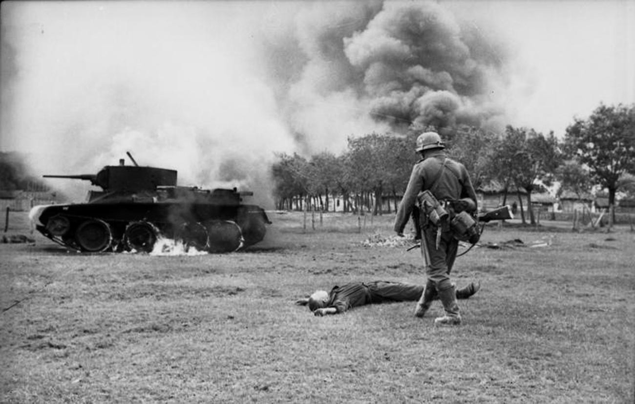 ドイツ軍の歩兵は倒れたソ連の兵士と快速戦車BT-7の前