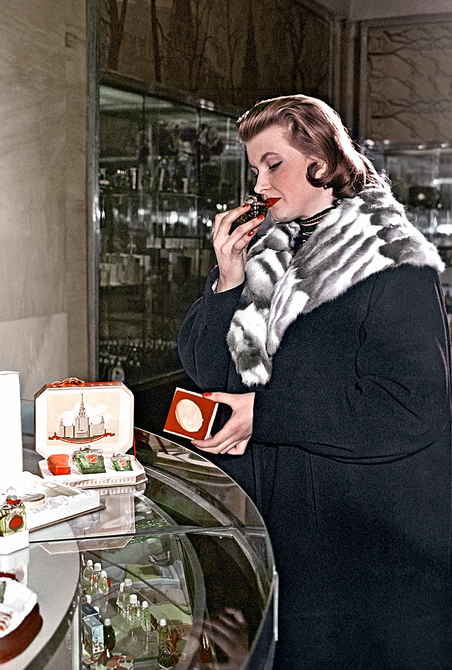 Покупательница у прилавка парфюмерного магазина в Охотном Ряду выбирает духи. 1958