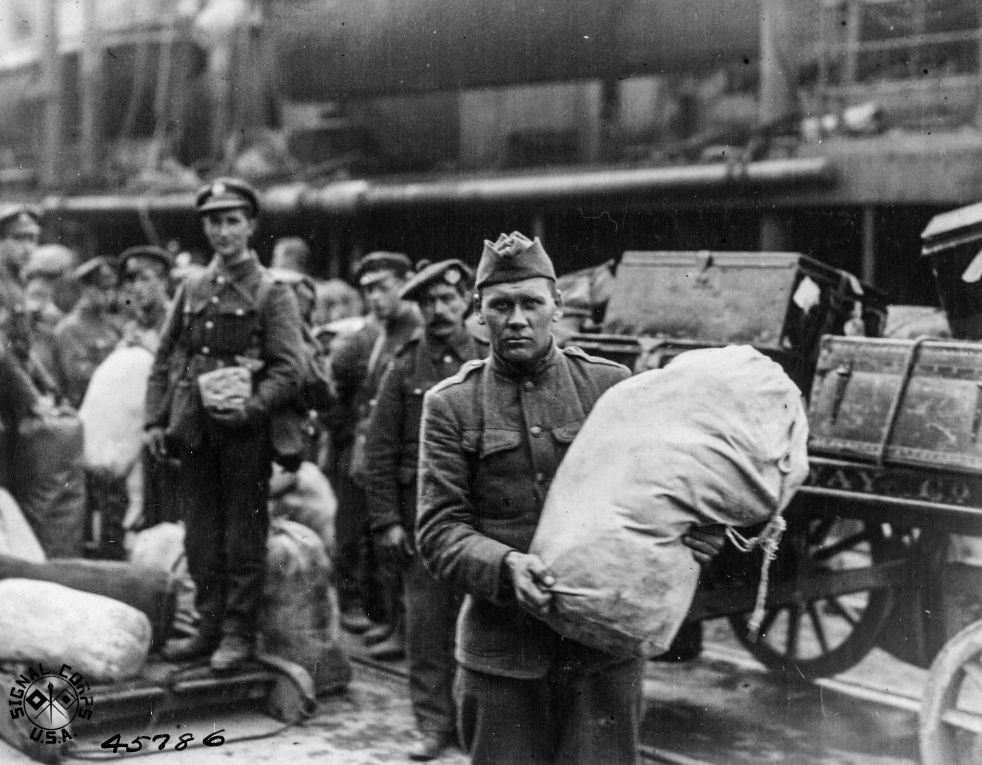 Un soldado estadounidense se detiene para una fotografía mientras carga suministros en un barco con destino a Rusia en 1918.


