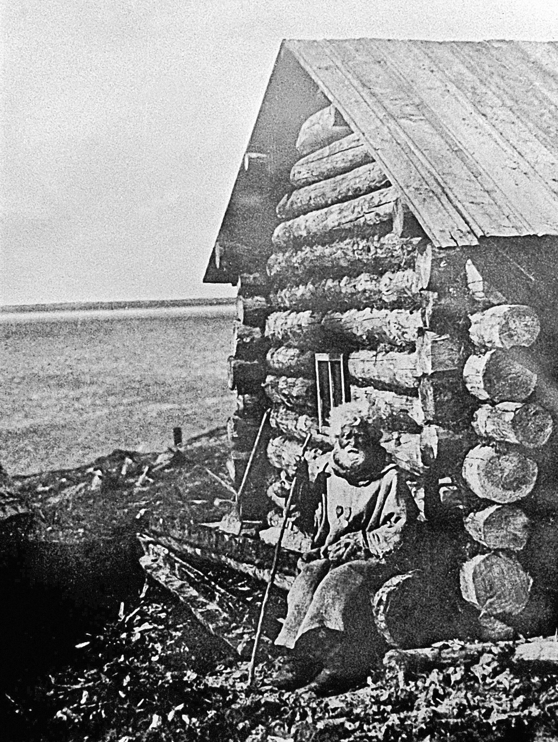 Один из первых жителей города Мурманска рыбак Семен Коржев у своей избы.