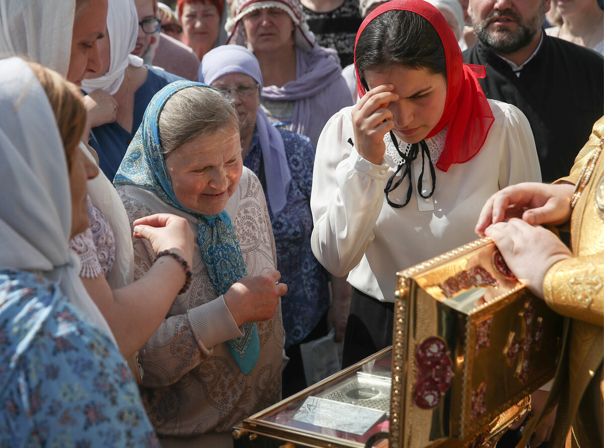 Russian Orthodox believers making the sign of the cross with three fingers