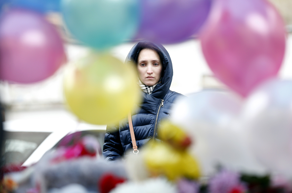 A woman grieves in front of the site near the Oktyabrskoye Pole underground station in Moscow, March 1, 2016, where a woman carrying a severed child's head was arrested. 