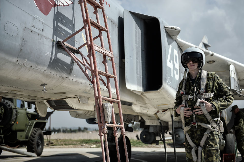 Seorang pilot Angkatan Udara Rusia di samping pesawat multiperan Su-24 di Pangkalan Udara Hmeimim, di Provinsi Latakia, Suriah.