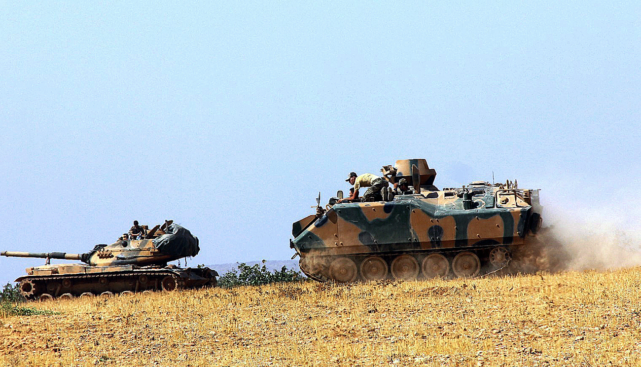 Sebuah tank tentara Turki dan sebuah kendaraan lapis baja ditempatkan di dekat perbatasan Turki dengan Suriah, di Karkamis, Turki.