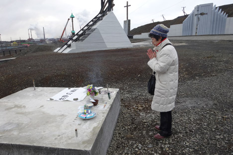 渡辺祥子さんが慰霊碑建立予定地で祈る。＝マリア・レブローヴァ撮影
