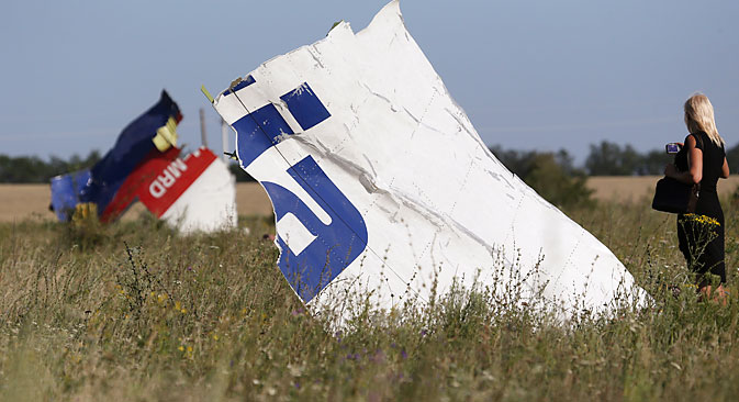 Жена фотографира остатоци од паднатиот авион на Малезија Ерлајнс МН17 во близина на селото Грабово, Донецка област